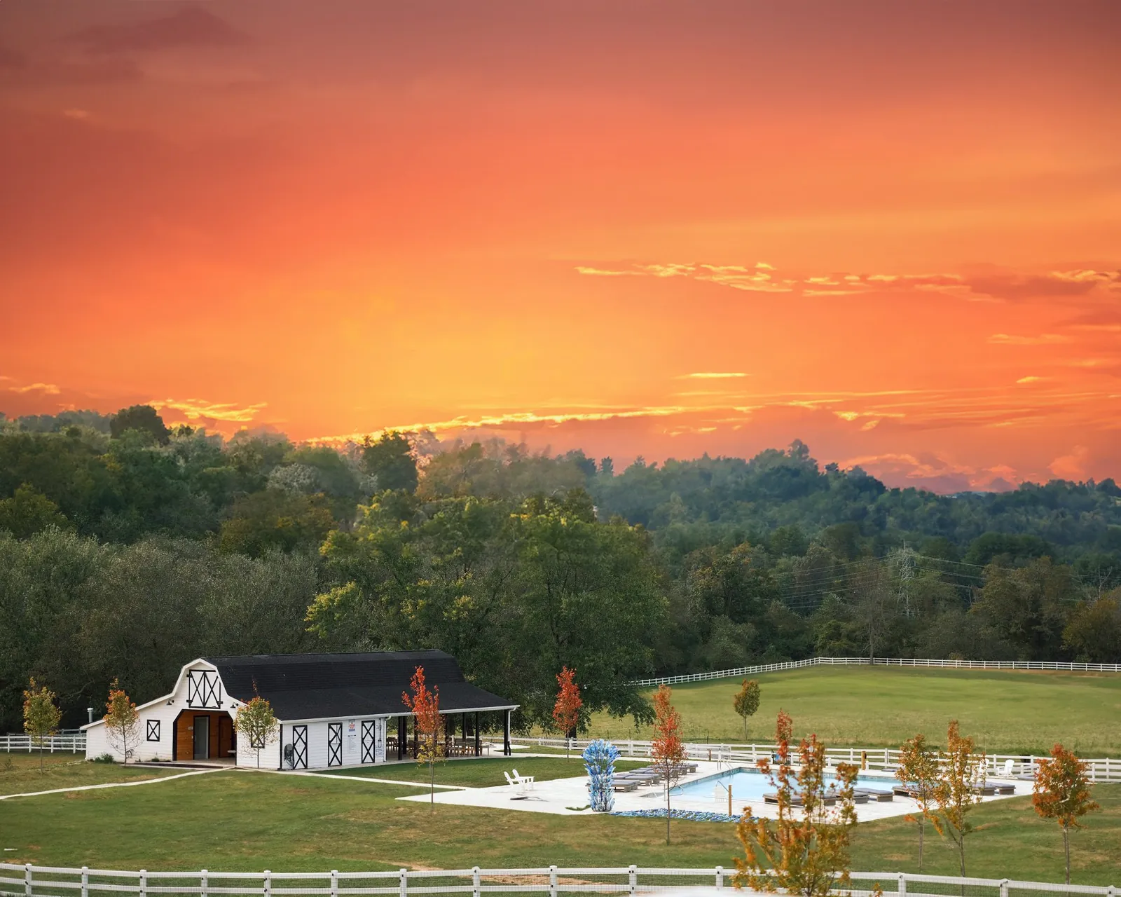 The white pool house at The Horse Shoe Farm with a covered porch and loungers out front